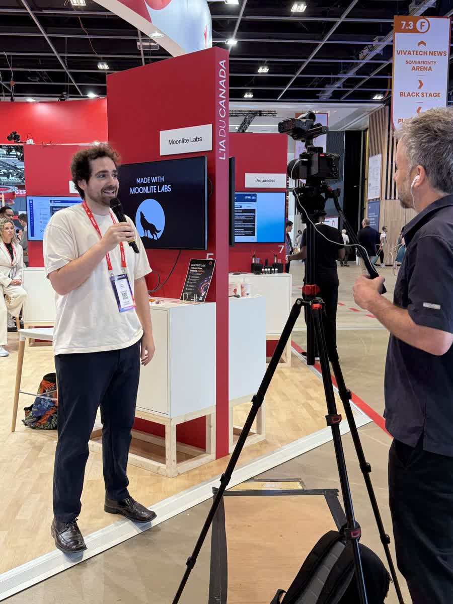 Moonlite Labs founder Adam Fainman speaking into a microphone in front of a camera at the Canada Pavilion at VivaTech Paris
