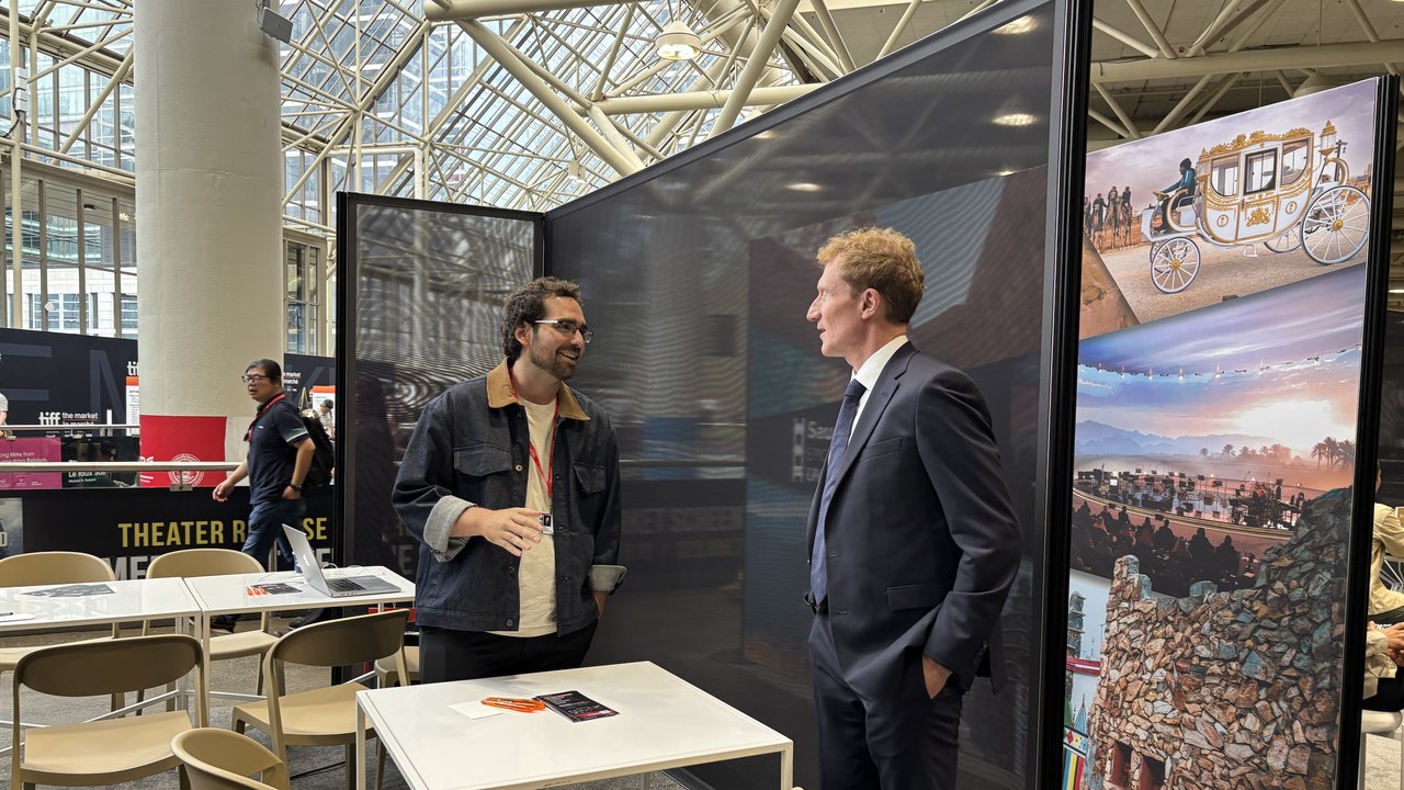 Minister Marc Miller, in a dark suit, talking with Adam Fainman at the Moonlite Labs booth